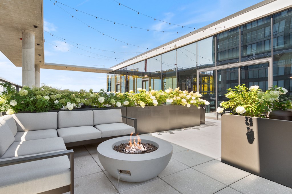 an outdoor patio with couches and a fire pit