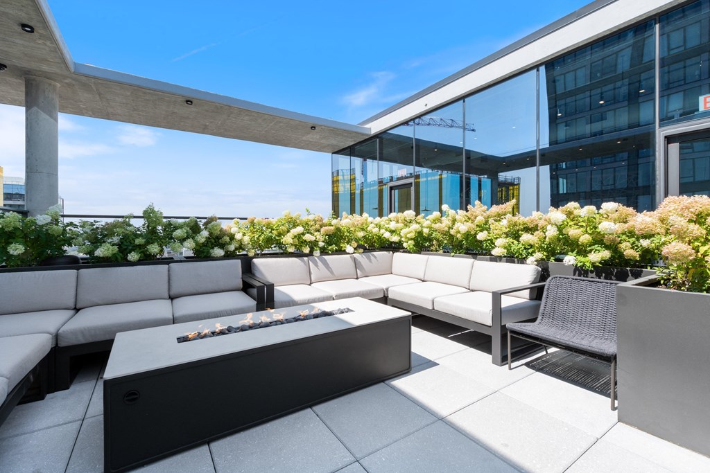 a terrace with couches and a firepit on the top of a building