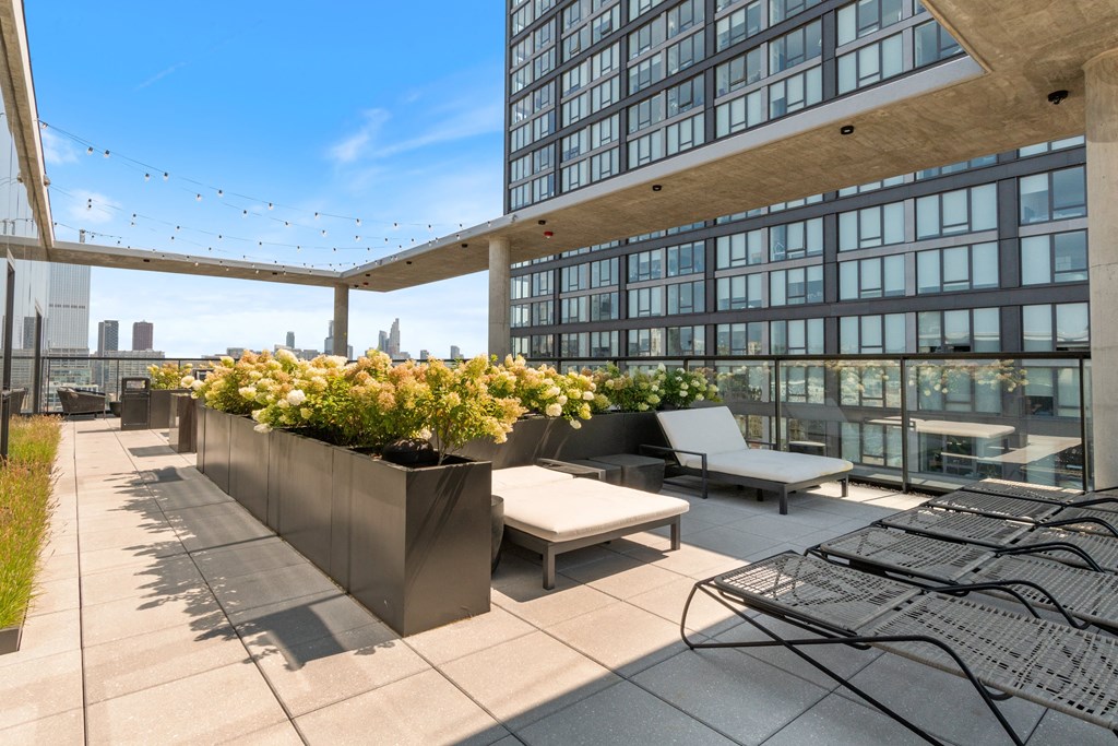 a roof top terrace with lounge chairs and a view of the chicago skyline