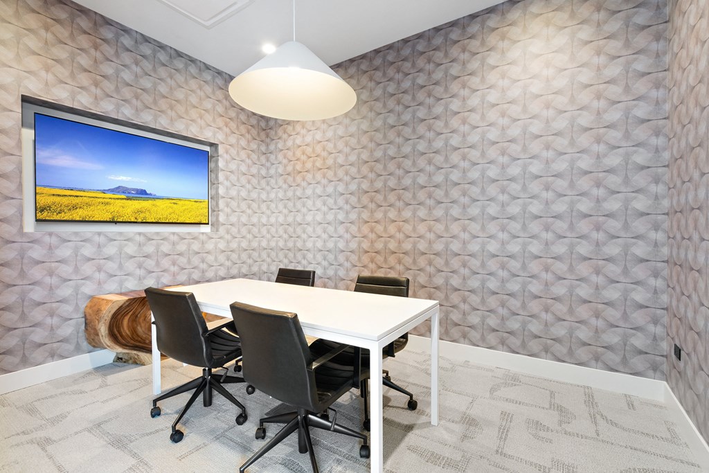 a meeting room with a white table and black chairs