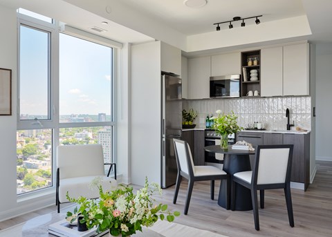 A modern kitchen with a dining table and chairs.