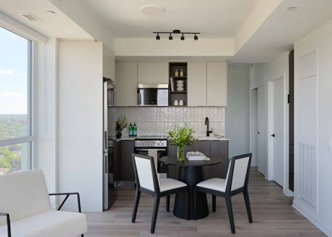 A modern kitchen with a dining table set for two.