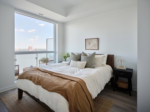 A bedroom with a large bed and a view of the city.