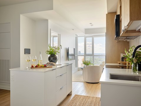 A modern kitchen with a white countertop and a large window.