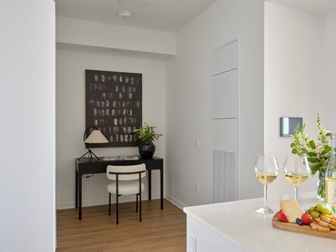 A dining table with a white chair and a black lamp with a white shade.