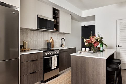 A modern kitchen with a stainless steel refrigerator and a wooden island.