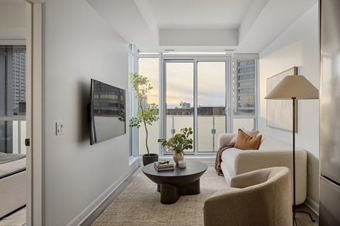 A living room with a flat screen TV mounted on the wall.