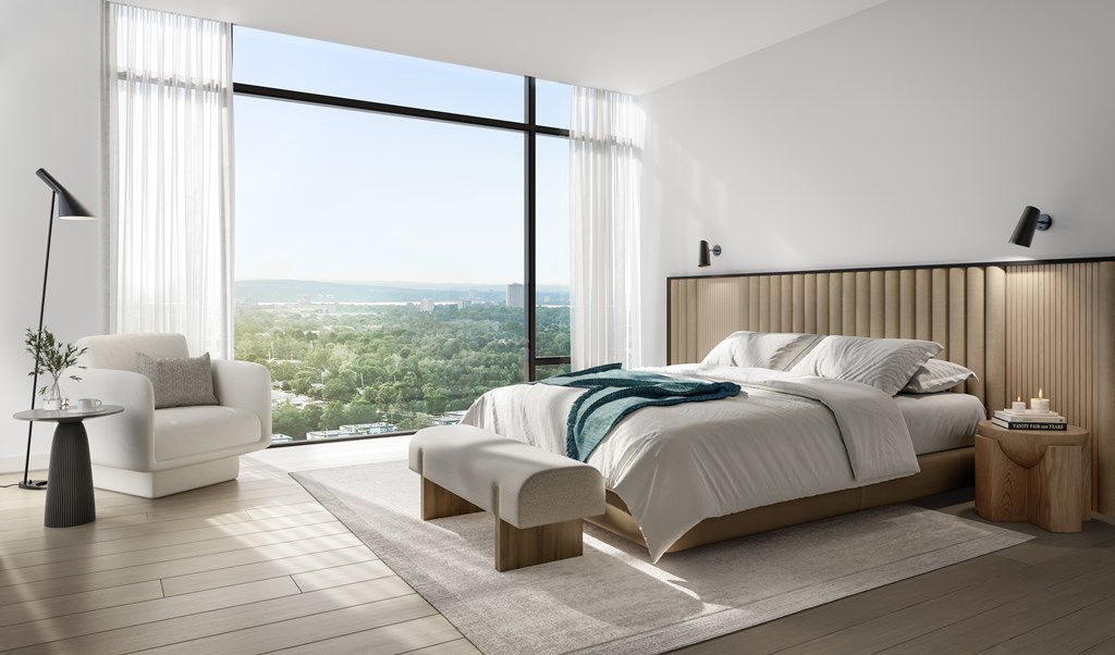 A modern bedroom with a large bed and a view of the city.