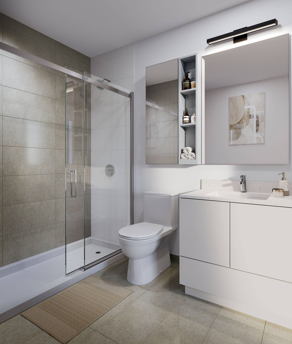 A modern bathroom with a toilet, sink, and shower.