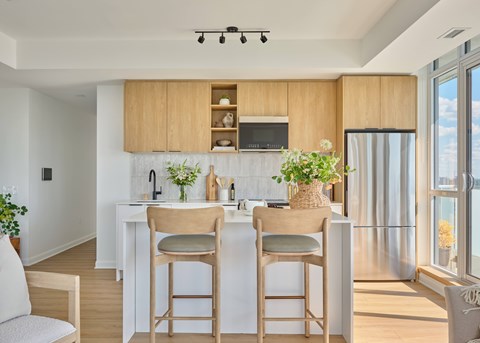 A kitchen with wooden chairs and a white counter.