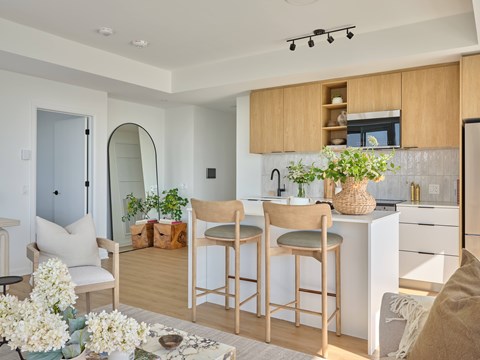 A kitchen with wooden chairs and a white counter.