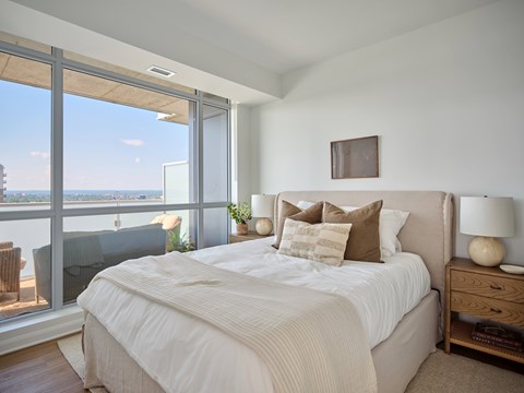 A bedroom with a large bed and a view of the ocean.
