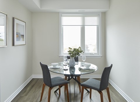 a dining room with a table and chairs and a window