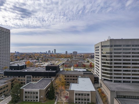 an aerial view of the city with buildings and a blue cloudy sky