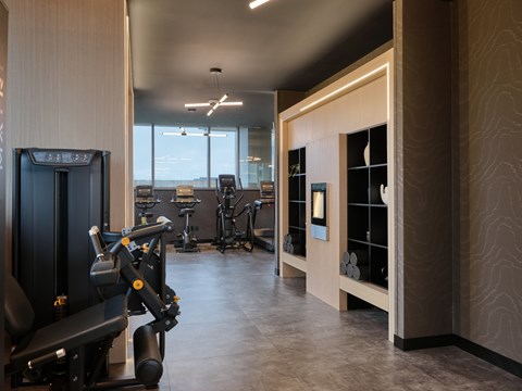 A gym with a row of treadmills and other exercise equipment.