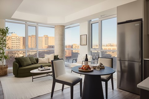 A modern kitchen with a table set for two and a view of the city.