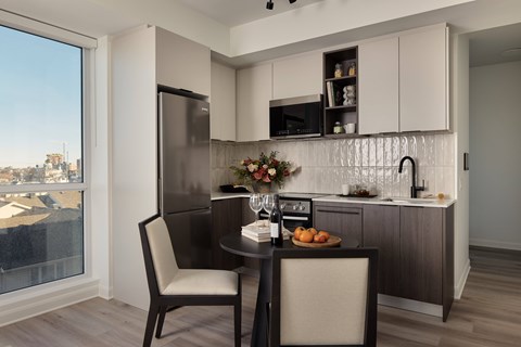A modern kitchen with a table set for two.