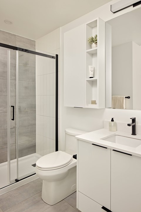 A white toilet sits next to a sink in a modern bathroom.