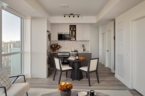 A modern kitchen with a dining table set for two.