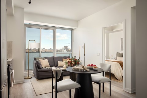 A modern dining room with a table set for four and a view of the city.