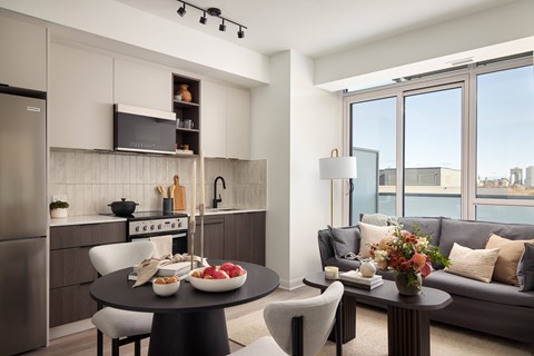 A modern kitchen with a dining table set with food and a couch with pillows.