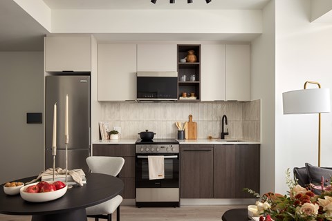 A modern kitchen with a refrigerator, oven, and sink.