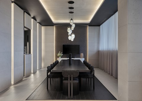 A modern dining room with a long table and chairs.