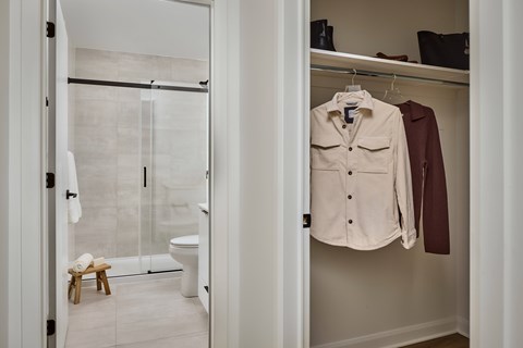 A white bathroom with a walk in shower and a white toilet.