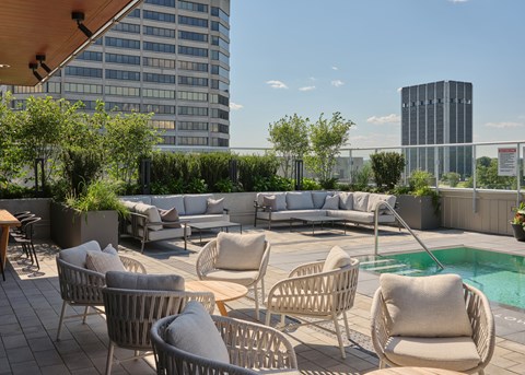 A rooftop with a pool and chairs.