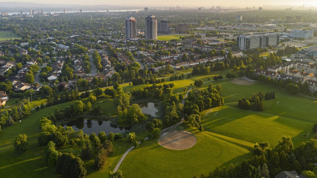 A golf course is surrounded by a city.