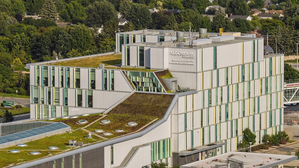 A modern building with a green roof and a sign that reads "Alcassis".