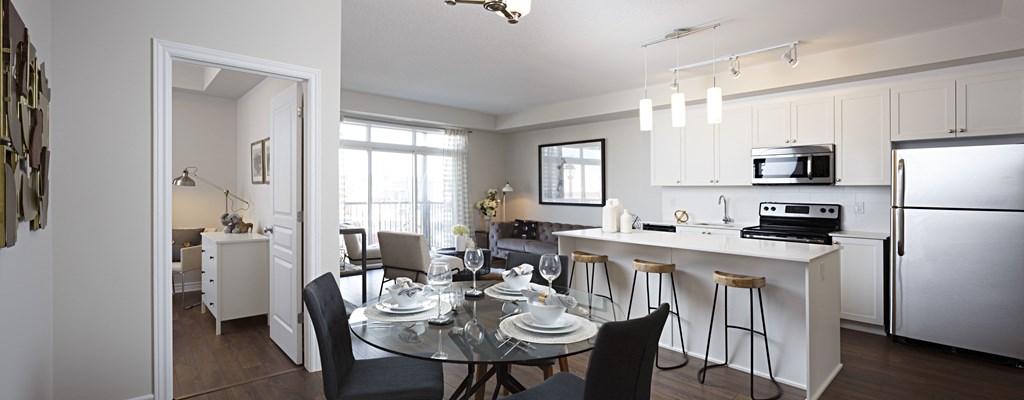an open kitchen and dining room with a glass table and chairs