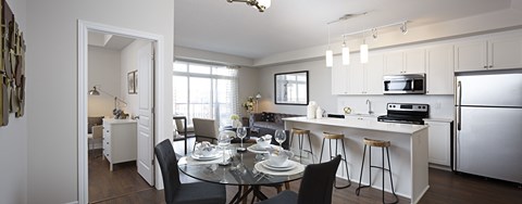 an open kitchen and dining room with a glass table and chairs