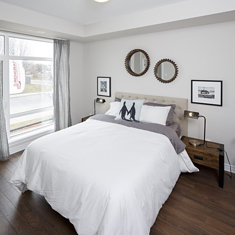 a bedroom with a bed and two mirrors on the wall