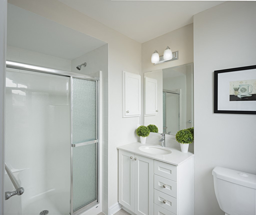 a white bathroom with a shower sink and toilet