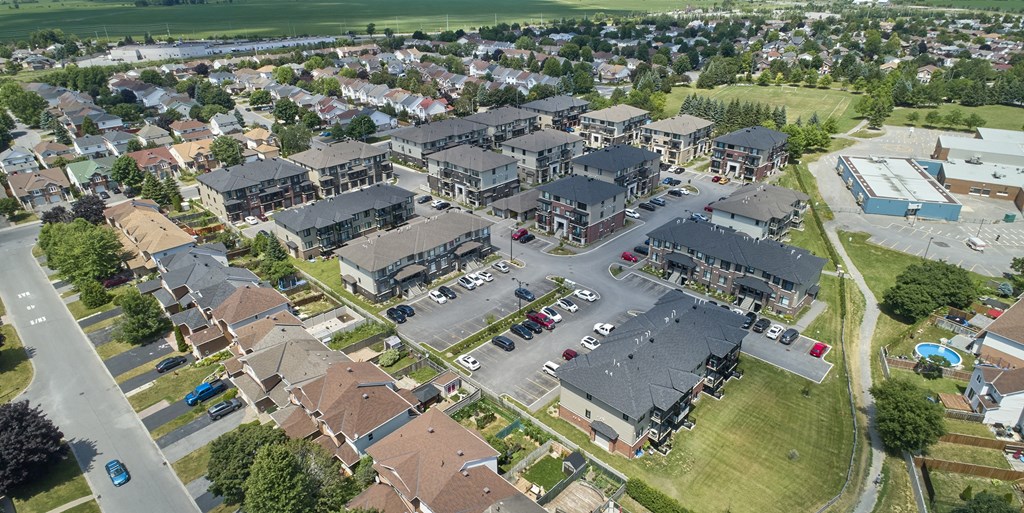an aerial view of a neighborhood of houses with cars in a parking lot