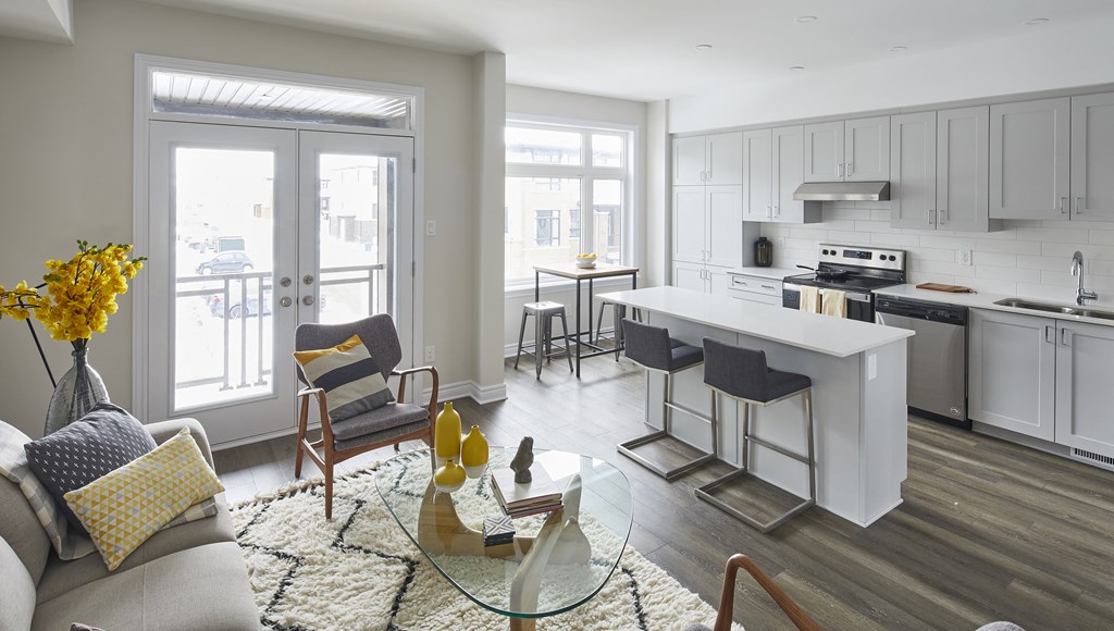 a living room with a couch and a table in front of a kitchen