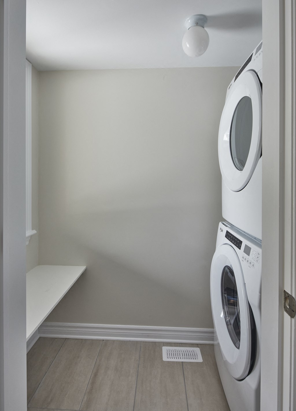 a white washer and dryer in a white laundry room with a wood floor