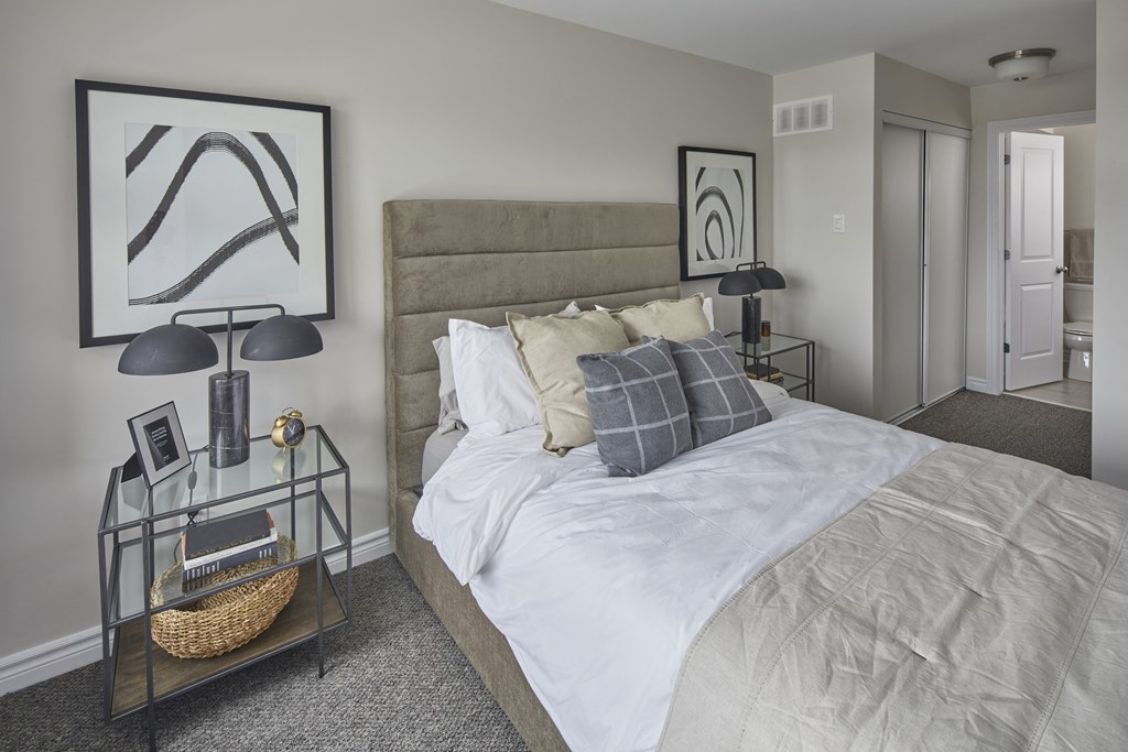 a bedroom with a large bed and a painting on the wall