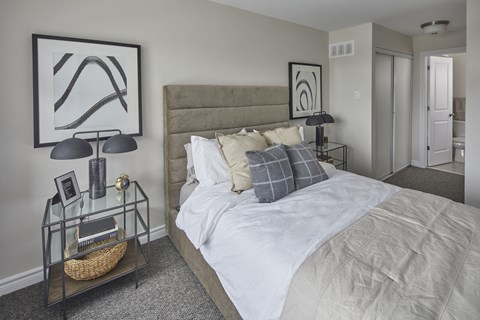 a bedroom with a large bed and a painting on the wall