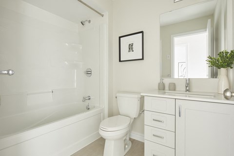 a white bathroom with a toilet and a bath tub