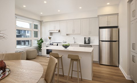 an open kitchen and dining area with a white island and stools