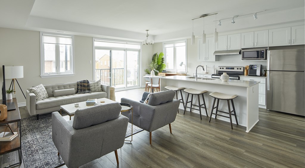 a living area with a kitchen and a couch and chairs