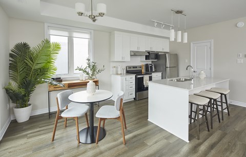 a kitchen with white cabinets and a white table and chairs