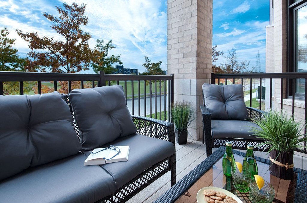 a patio with couches and chairs on a balcony