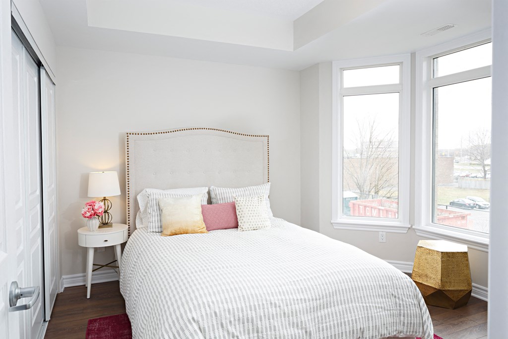 a bedroom with a large bed and three windows