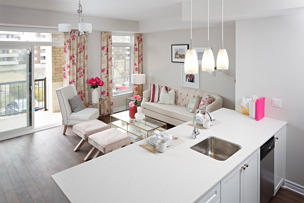 a kitchen and living room with a white counter top and a glass table