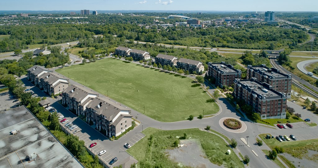 an aerial view of apartment buildings and a green field
