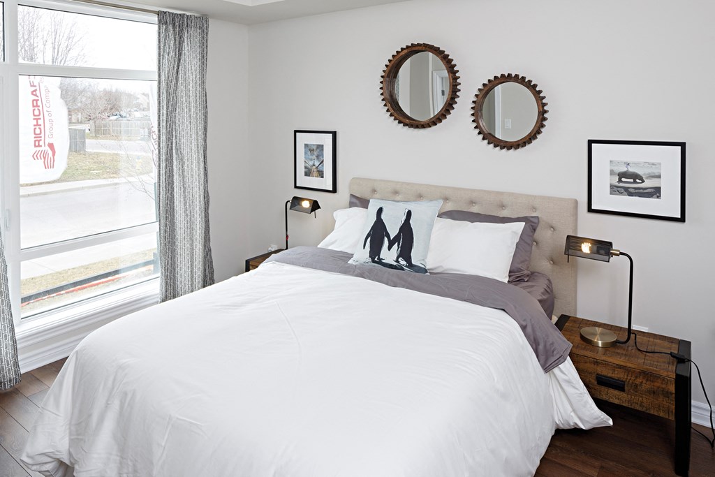 a bedroom with a bed and two mirrors on the wall