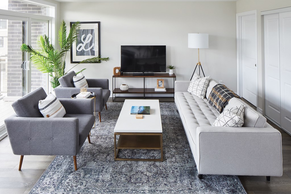 a living room with couches chairs and a coffee table and a television